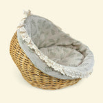 Load image into Gallery viewer, Wicker pet bed with gray floral fabric lining on a beige background
